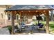The backyard pergola features a stone patio with comfortable seating, a mounted tv, and elegant outdoor decor at 255 Capellan St, Wake Forest, NC 27587