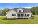 Spacious backyard showcasing a charming home with a screened porch, wooden deck, and lush green lawn at 257 Reese Dr, Willow Springs, NC 27592