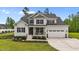 Charming two-story home with a covered front porch, beautiful landscaping, and a two-car garage at 257 Reese Dr, Willow Springs, NC 27592
