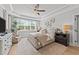 Serene main bedroom with a tray ceiling, natural light, and a cozy sitting area at 257 Reese Dr, Willow Springs, NC 27592