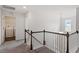 Bright upstairs hallway with white paint, carpet, white railings, and natural light at 30 Dowdy Ct, Youngsville, NC 27596