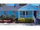 Charming blue home featuring a cozy front porch, well-maintained landscaping, and stone garden border at 307 S Smithfield Rd, Knightdale, NC 27545