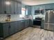 Well-equipped kitchen featuring gray cabinets, stainless steel appliances, and stunning backsplash, and wood-look floors at 307 S Smithfield Rd, Knightdale, NC 27545