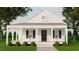 Charming home with a covered porch, black shutters and door, surrounded by lush greenery and mature trees at 329 Green Pines Estates Dr, Kenly, NC 27542
