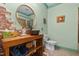 Quirky bathroom with exposed brick, round mirror, and rustic wooden vanity showcasing a copper vessel sink at 342 Mcleod Rd, Broadway, NC 27505