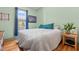 Cozy bedroom featuring hardwood floors, a comfortable bed with blue accents, and a view of the greenery outside at 342 Mcleod Rd, Broadway, NC 27505