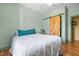 Bedroom features a light-colored wooden sliding door, light green walls, and a comfortable bed with a modern ceiling fan at 342 Mcleod Rd, Broadway, NC 27505