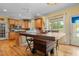 Well-lit kitchen features an island with seating, wooden cabinets, and a view of the screened-in porch and lush backyard at 342 Mcleod Rd, Broadway, NC 27505