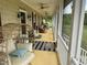Inviting screened-in porch with comfortable seating, ceiling fans, and views of the landscaped yard at 342 Mcleod Rd, Broadway, NC 27505