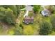 Aerial view of the backyard with deck, lawn, shed, and lush, green trees at 35 Vauxhall Ct, Youngsville, NC 27596