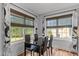 Bright dining area with large windows featuring stylish curtains, laminate flooring, and seating for four at a modern table at 35 Vauxhall Ct, Youngsville, NC 27596