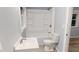 Clean bathroom featuring a shower-tub combo, white fixtures, and a bright window at 3610 Hawkins Ave, Sanford, NC 27330
