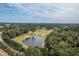 Aerial view of golf course, lake, green trees, and luxury neighborhood in the background at 3827 Heritage Spring Circle Cir, Wake Forest, NC 27587