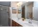 Bathroom featuring double sinks, framed mirror, and a shower with gray tile surround at 3827 Heritage Spring Circle Cir, Wake Forest, NC 27587