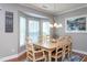 Bright dining room featuring wood table, elegant chandelier, bay window and neutral wall paint at 3827 Heritage Spring Circle Cir, Wake Forest, NC 27587