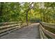 Outdoor wooden walking path and bridge surrounded by lush trees and green foliage, creating a scenic view at 3827 Heritage Spring Circle Cir, Wake Forest, NC 27587