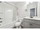Bright bathroom with a shower and tub combination and modern grey vanity at 3901 Bluffwind Dr, Raleigh, NC 27603