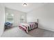 Bright bedroom featuring neutral walls, carpet, a cozy chair, and natural light from two windows at 3901 Bluffwind Dr, Raleigh, NC 27603