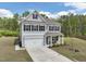 Charming two-story home featuring gray siding, black shutters, a well-manicured lawn, and an attached two-car garage at 3901 Bluffwind Dr, Raleigh, NC 27603