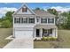 Charming two-story home featuring gray siding, black shutters, a well-manicured lawn, and an attached two-car garage at 3901 Bluffwind Dr, Raleigh, NC 27603