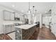 Modern kitchen with stainless steel appliances, a large center island with bar seating, and stylish pendant lighting at 3901 Bluffwind Dr, Raleigh, NC 27603