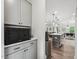 Bright kitchen with grey cabinets, granite countertops, stainless appliances, and view into the open concept living area at 3901 Bluffwind Dr, Raleigh, NC 27603
