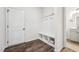 Mudroom with built in storage and dark vinyl flooring and a view into the bathroom at 3901 Bluffwind Dr, Raleigh, NC 27603