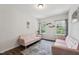 Sitting room with two pink couches, grey rug, dark vinyl flooring, and natural lighting at 3901 Bluffwind Dr, Raleigh, NC 27603