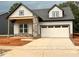 Charming single-Gathering home with a gray exterior, stone accents, and a two-car garage at 40 Wabash St, Pittsboro, NC 27312