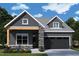 Charming single-Gathering home featuring stone accents, gray siding, and an attached two-car garage at 40 Wabash St, Pittsboro, NC 27312
