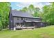 Spacious backyard with a deck, screened porch, and a lush lawn surrounded by mature trees at 401 Brinkman Ct, Raleigh, NC 27614