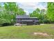 Large backyard featuring a deck, screened porch, lush green lawn, and mature trees creating a private oasis at 401 Brinkman Ct, Raleigh, NC 27614