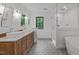 Bright bathroom featuring double vanity, freestanding tub, and modern tiled shower at 401 Brinkman Ct, Raleigh, NC 27614