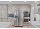 Open kitchen with stainless appliances, custom gray cabinets and a white marble countertop island at 401 Brinkman Ct, Raleigh, NC 27614
