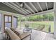 Screened porch with cushioned seating, ceiling fan, view of landscaped backyard and wooded area at 401 Brinkman Ct, Raleigh, NC 27614