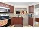 Functional kitchen featuring stainless steel appliances, granite countertops, and dark wood cabinets at 4125 Palafox Ct, Raleigh, NC 27604