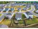 Aerial view of a home with a beautifully landscaped backyard, stone patio and fire pit, garden, and fenced yard at 4333 Benton Mill Dr, Fuquay Varina, NC 27526