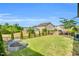 Wide view of the backyard featuring a well-kept lawn, a garden with raised beds, and a beautiful stone patio with a fire pit at 4333 Benton Mill Dr, Fuquay Varina, NC 27526