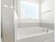Bright bathroom featuring a soaking tub with gray tiling, window, and chrome hardware at 4333 Benton Mill Dr, Fuquay Varina, NC 27526