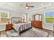 Primary bedroom with tray ceilings, ceiling fan, wood floors, and three windows for natural light at 4333 Benton Mill Dr, Fuquay Varina, NC 27526