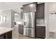 Kitchen boasts stainless steel refrigerator, gray cabinets, stone countertops, and wood flooring at 4333 Benton Mill Dr, Fuquay Varina, NC 27526
