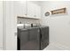 Well-equipped laundry room with gray front load washer and dryer plus storage cabinets at 4333 Benton Mill Dr, Fuquay Varina, NC 27526