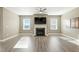 Bright living room featuring a fireplace, large windows, ceiling fan, and wood flooring at 4333 Benton Mill Dr, Fuquay Varina, NC 27526