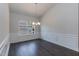Elegant dining room with wainscoting, dark wood floors and a modern light fixture at 44 Cooper Branch Ct, Fuquay Varina, NC 27526