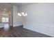 Spacious dining room with an elegant chandelier, wainscoting, and hardwood flooring at 44 Cooper Branch Ct, Fuquay Varina, NC 27526