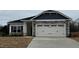 Charming home featuring a stone facade, white garage door and black shutters at 44 Cooper Branch Ct, Fuquay Varina, NC 27526