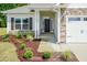 Inviting home exterior with stone accents, a black front door, and landscaped garden at 44 Cooper Branch Ct, Fuquay Varina, NC 27526