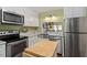 Well-lit kitchen featuring stainless steel appliances, white cabinets, and butcher block island for food preparation at 4617 Fawnbrook Cir, Raleigh, NC 27612