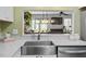 Bright kitchen showcasing stainless steel sink, white cabinets, and open layout to living room with nice decor at 4617 Fawnbrook Cir, Raleigh, NC 27612
