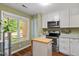 Charming kitchen featuring stainless steel appliances, white cabinetry, and a bright window with scenic view at 4617 Fawnbrook Cir, Raleigh, NC 27612